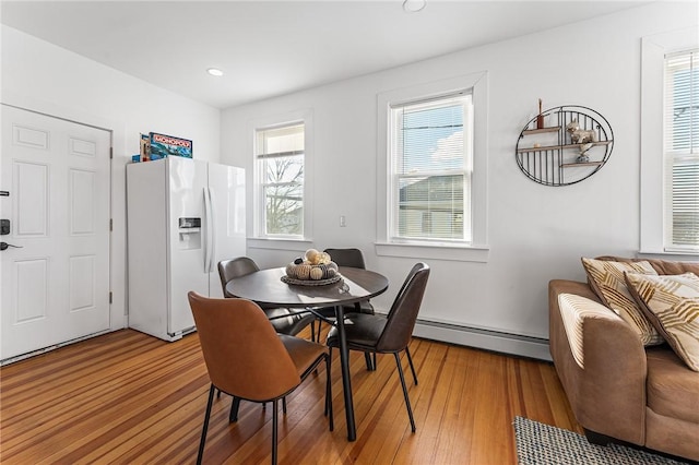 dining space with wood-type flooring and baseboard heating