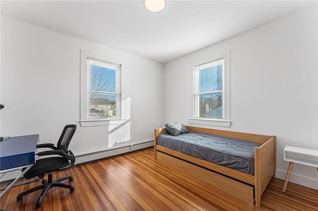 bedroom with hardwood / wood-style floors and a baseboard radiator