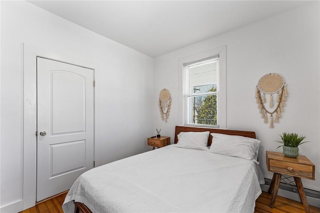 bedroom featuring wood-type flooring and baseboard heating