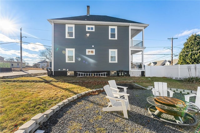 back of property featuring a balcony and a yard