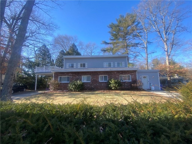 traditional home with a carport, brick siding, and a front yard