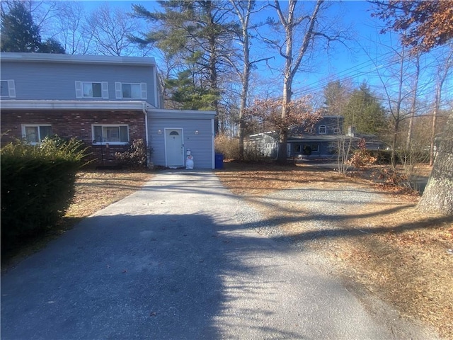 view of front facade with aphalt driveway and brick siding