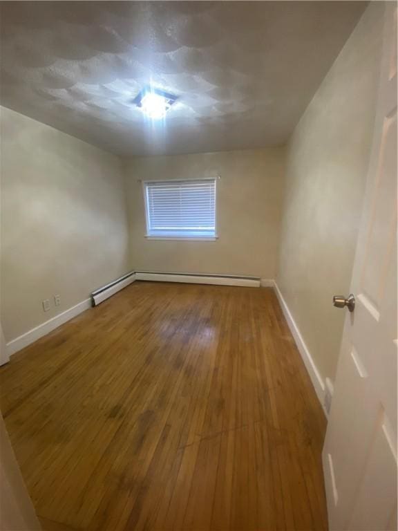 spare room featuring baseboards and hardwood / wood-style floors