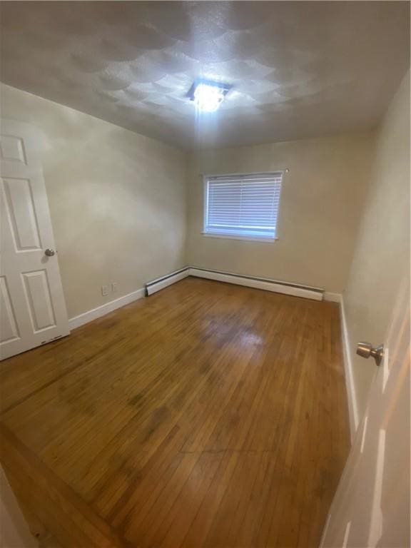 empty room featuring baseboards and hardwood / wood-style floors