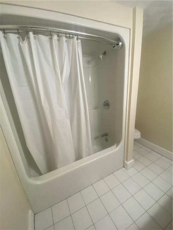 full bathroom with toilet, tile patterned flooring, shower / bathtub combination with curtain, and baseboards