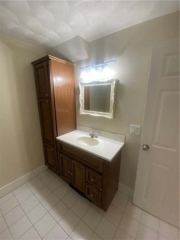 bathroom featuring tile patterned flooring, baseboards, and vanity