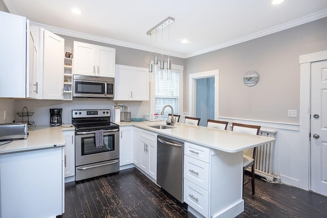 kitchen with white cabinets, a breakfast bar, sink, and appliances with stainless steel finishes