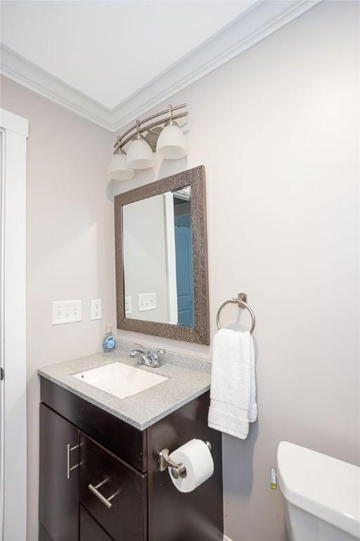 bathroom featuring vanity, toilet, and crown molding