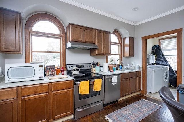 kitchen with ornamental molding, sink, washer and dryer, and appliances with stainless steel finishes