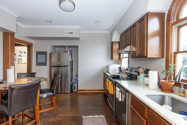 kitchen featuring crown molding, sink, appliances with stainless steel finishes, and dark wood-type flooring