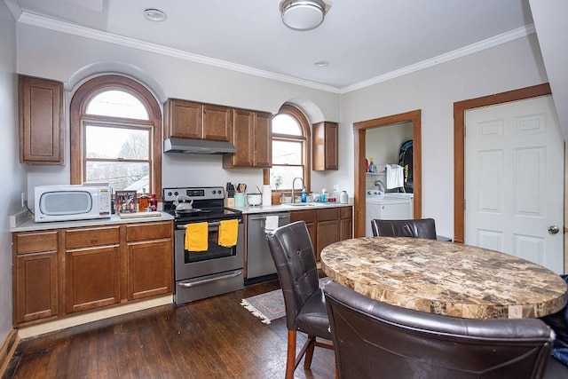 kitchen featuring sink, separate washer and dryer, crown molding, plenty of natural light, and appliances with stainless steel finishes