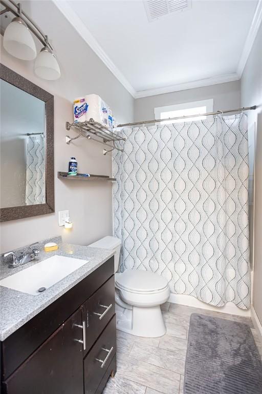 full bathroom featuring toilet, vanity, crown molding, and shower / bath combo with shower curtain