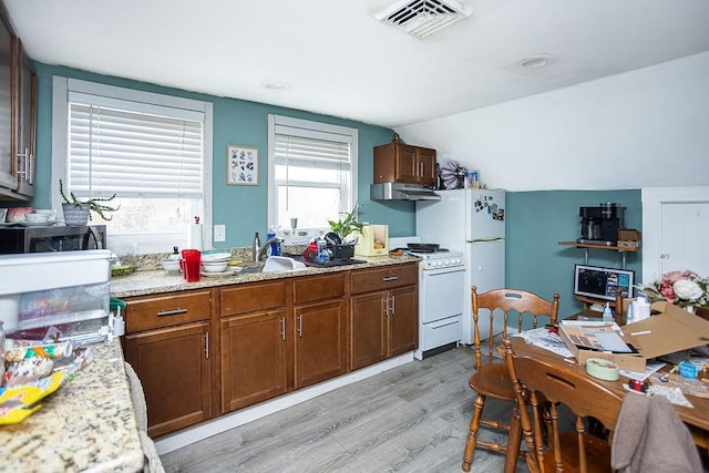 kitchen with light stone countertops, sink, light hardwood / wood-style flooring, lofted ceiling, and white appliances