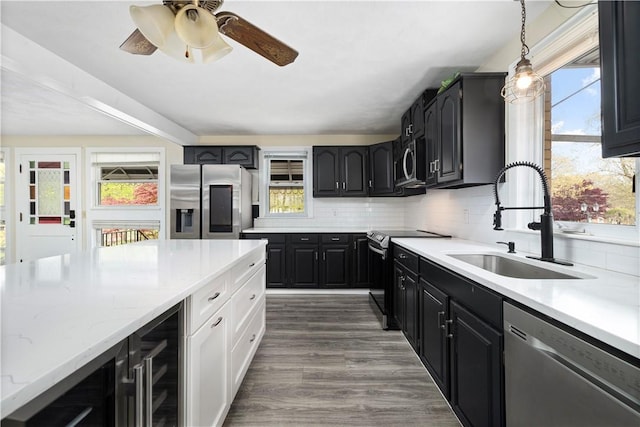 kitchen with sink, tasteful backsplash, dark hardwood / wood-style floors, pendant lighting, and appliances with stainless steel finishes