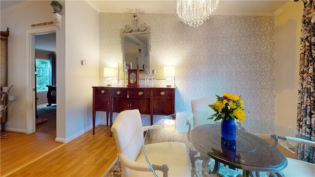 dining area featuring hardwood / wood-style flooring, crown molding, and a notable chandelier