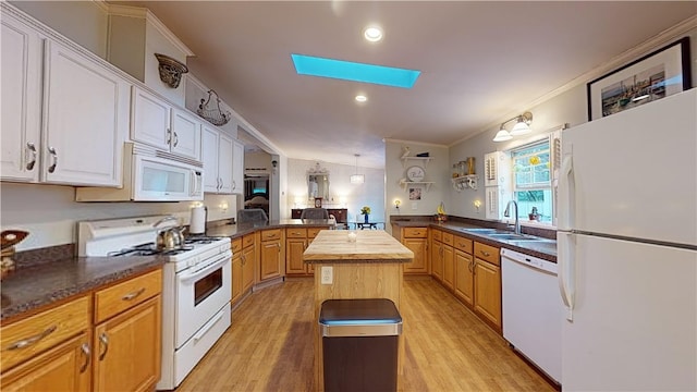 kitchen with a center island, sink, wood counters, crown molding, and white appliances