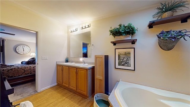 bathroom with hardwood / wood-style flooring, vanity, ornamental molding, and a bath