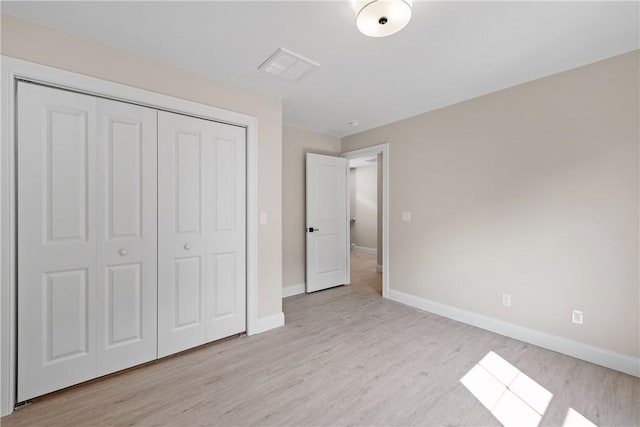 unfurnished bedroom with a closet and light hardwood / wood-style floors