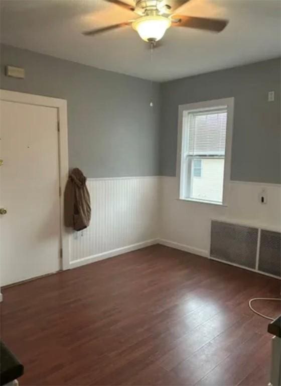 empty room featuring dark hardwood / wood-style flooring and ceiling fan