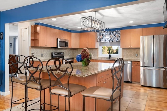 kitchen featuring tasteful backsplash, sink, a center island, and stainless steel appliances