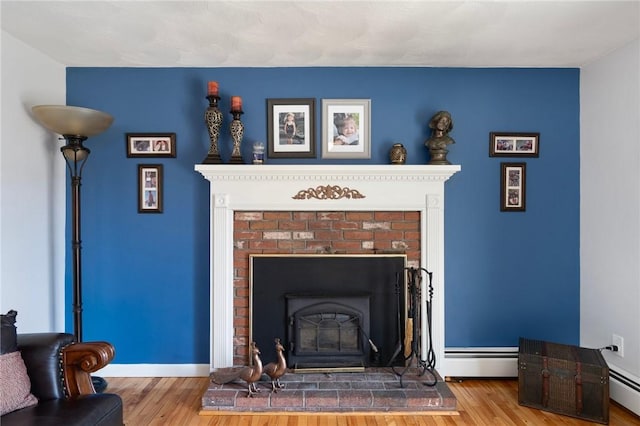 room details with a fireplace, wood-type flooring, and baseboard heating