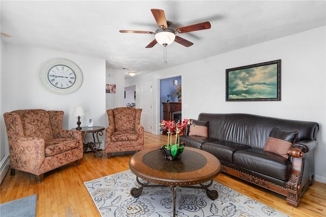 living room with ceiling fan and light hardwood / wood-style floors