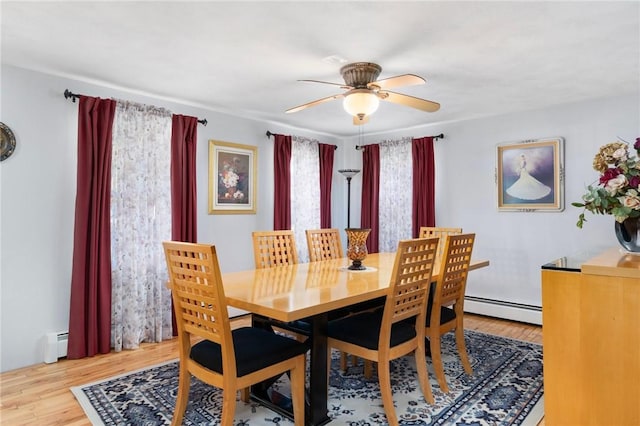 dining room with light wood-type flooring, baseboard heating, and ceiling fan