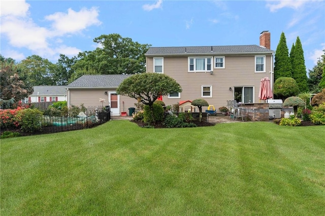 back of property with a lawn and a patio area