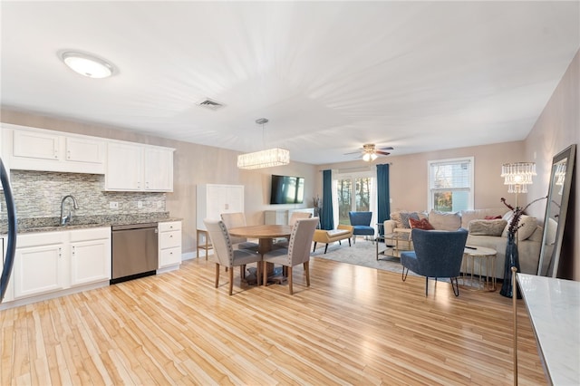 dining space with ceiling fan, sink, and light wood-type flooring