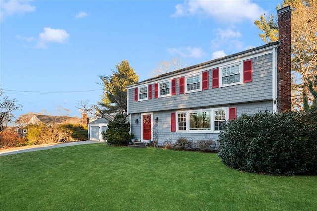 view of front of home with a front lawn, an outdoor structure, and a garage