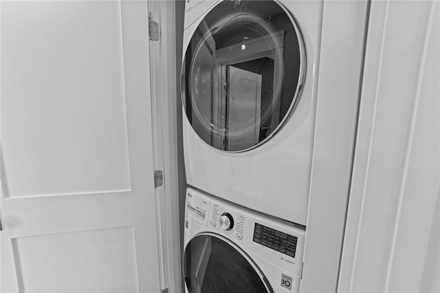 clothes washing area featuring stacked washer and dryer