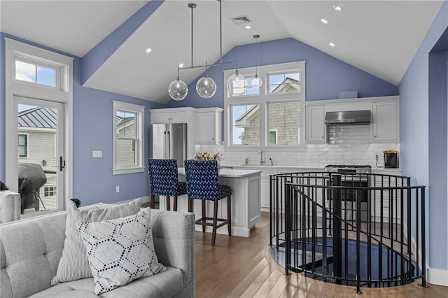 kitchen with white cabinets, stainless steel appliances, tasteful backsplash, and hanging light fixtures