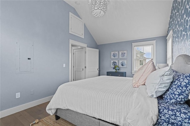 bedroom featuring electric panel, vaulted ceiling, hardwood / wood-style flooring, and a notable chandelier