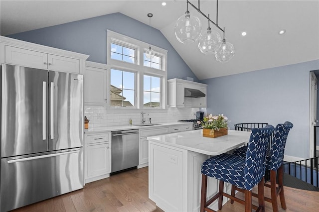 kitchen featuring sink, white cabinets, stainless steel appliances, and a kitchen island