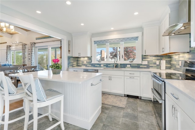 kitchen featuring white cabinetry, sink, wall chimney exhaust hood, and appliances with stainless steel finishes