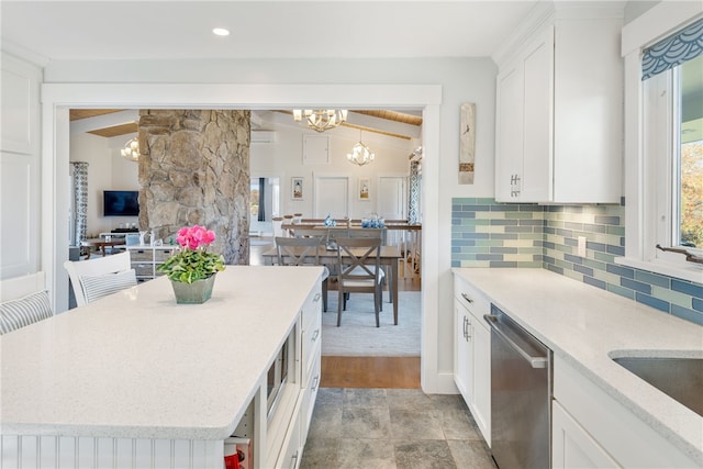 kitchen featuring white cabinets, dishwasher, a healthy amount of sunlight, and vaulted ceiling