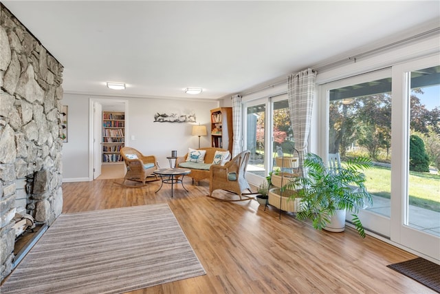 living room featuring a stone fireplace and hardwood / wood-style flooring