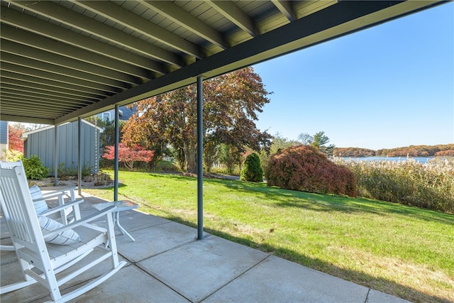 view of patio / terrace featuring a water view and a storage shed