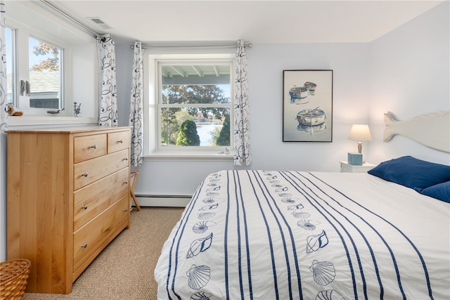 bedroom with multiple windows, light carpet, and a baseboard radiator