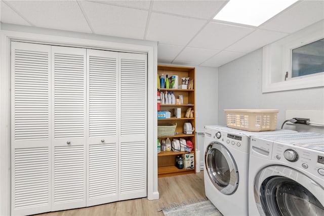 clothes washing area featuring light wood-type flooring and washing machine and clothes dryer