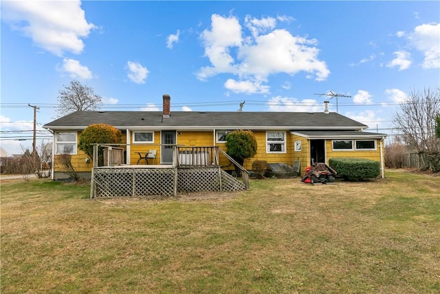 rear view of property with a lawn and a wooden deck