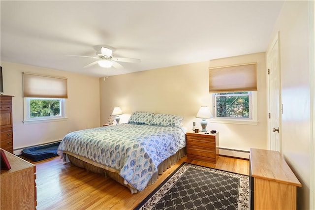 bedroom with ceiling fan, multiple windows, and a baseboard radiator