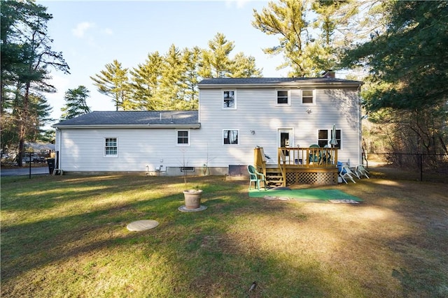 back of property with a wooden deck and a yard