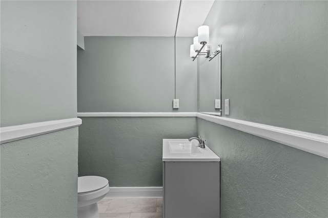 bathroom featuring vanity, toilet, and an inviting chandelier