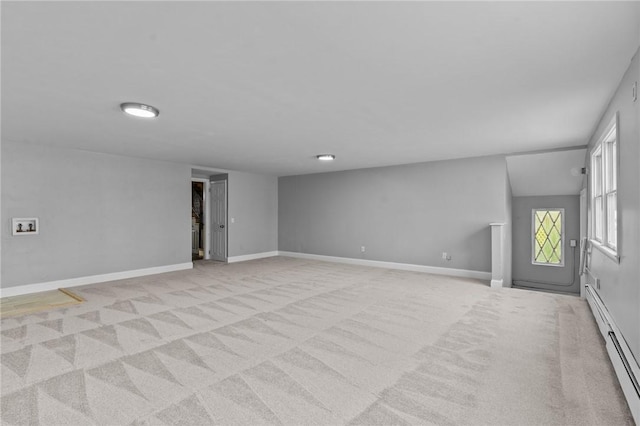 unfurnished living room with lofted ceiling, light carpet, and baseboard heating