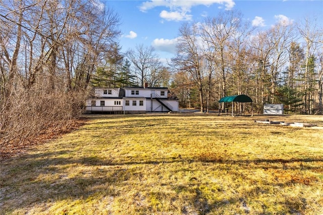 view of yard featuring a deck and a storage shed