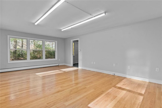 spare room featuring a baseboard radiator and light hardwood / wood-style flooring