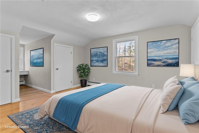 bedroom featuring wood-type flooring, lofted ceiling, and baseboard heating