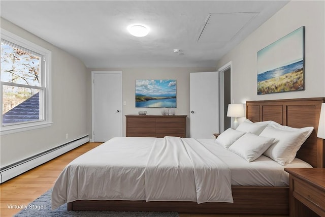 bedroom with wood-type flooring and a baseboard heating unit