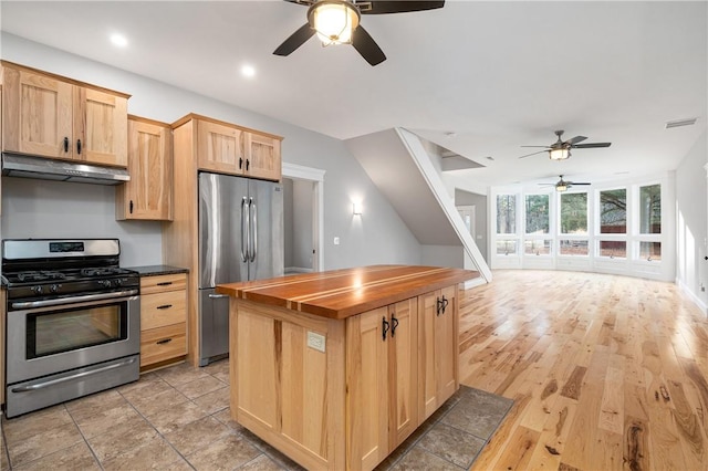 kitchen featuring light hardwood / wood-style flooring, ceiling fan, light brown cabinetry, appliances with stainless steel finishes, and butcher block countertops